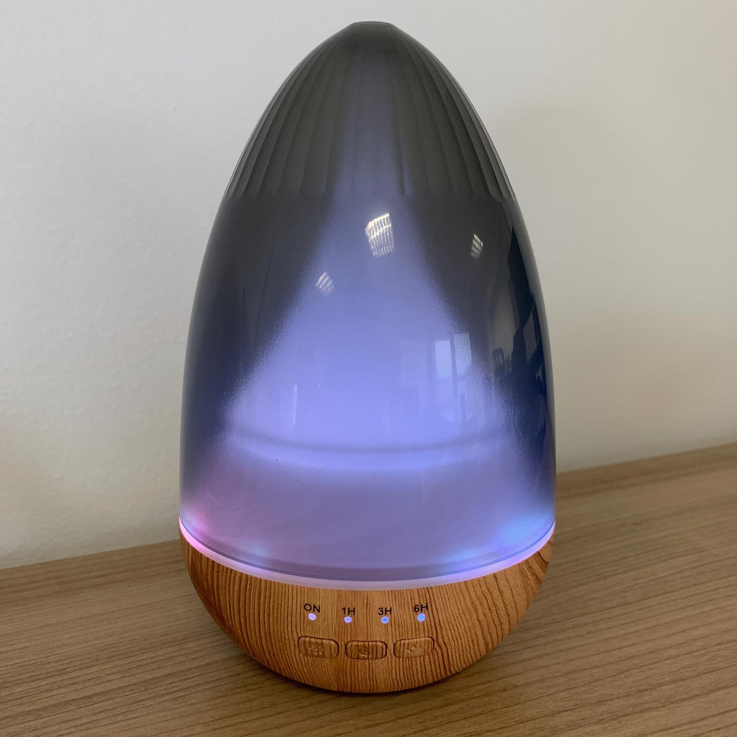 Aromatherapy egg-shaped diffuser with a gradient design on a wooden surface.