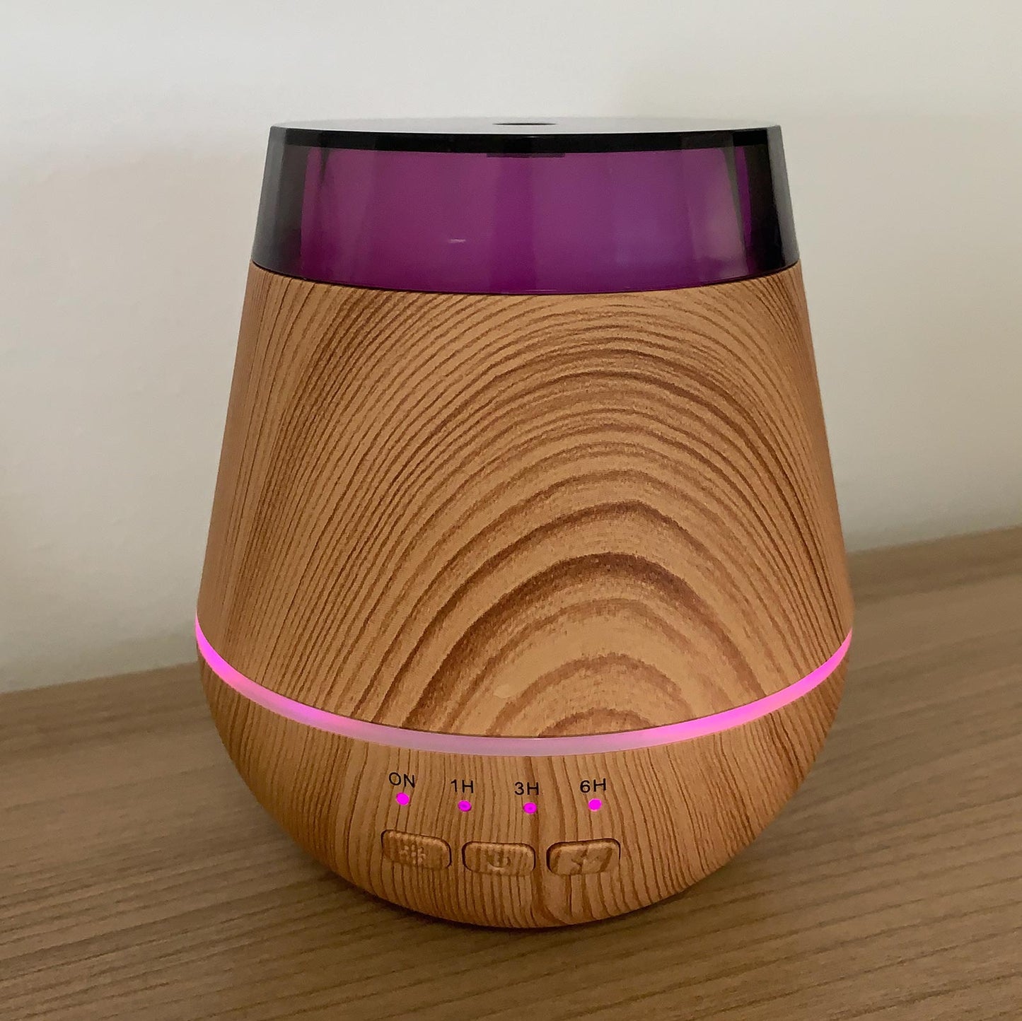 Wooden-textured diffuser with purple accents on a wooden surface